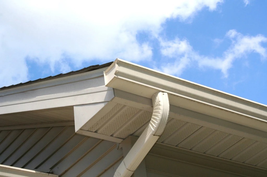 White vented soffit, fascia, gutter and downspout on a home exterior